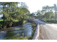 A view of the bridge leading up to the woodland entrance showing Afon Syfynwy
