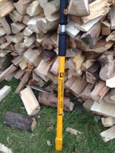 Splitting firewood logs, using a hand-held logsplitter