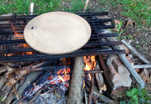 Cooking pizza on a campfire in a woodland